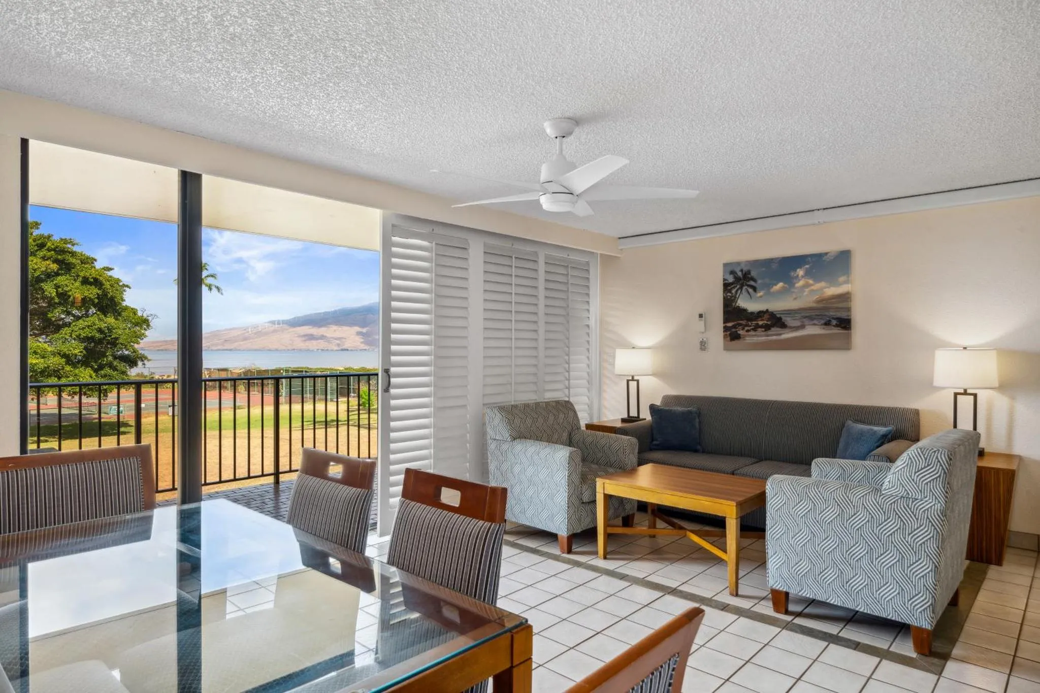 Espace de vie lumineux avec canapés et table à manger donnant sur une vue sur la mer.