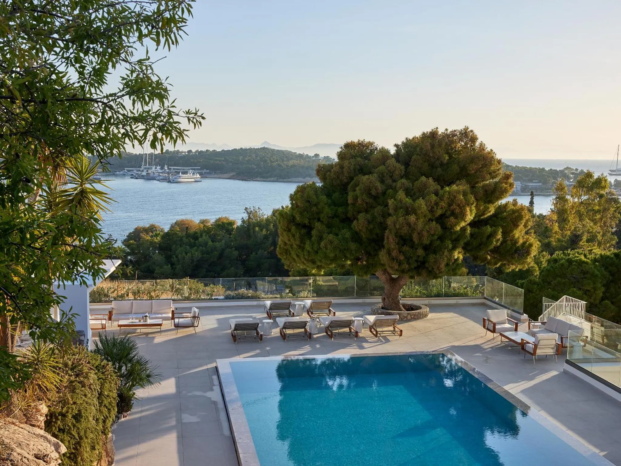 Terrasse avec transats et piscine donnant sur la mer.