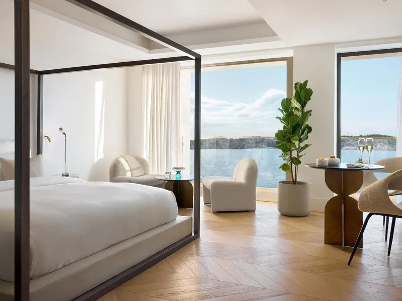 Une chambre lumineuse avec un grand lit et une vue sur la mer.