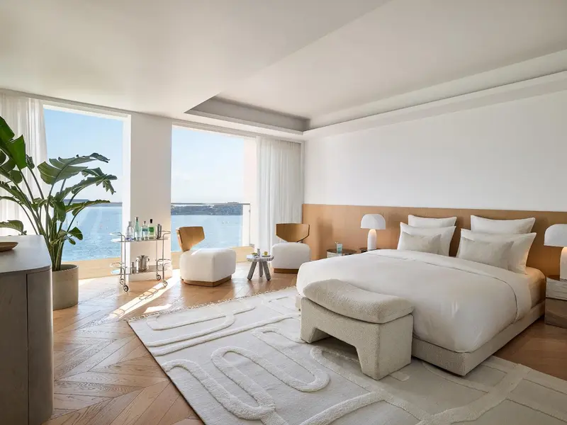 Une chambre lumineuse avec un grand lit et une vue sur la mer.