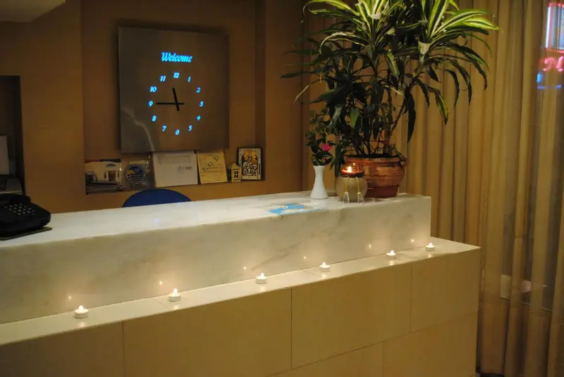 Un comptoir d'accueil lumineux avec une plante et une horloge.