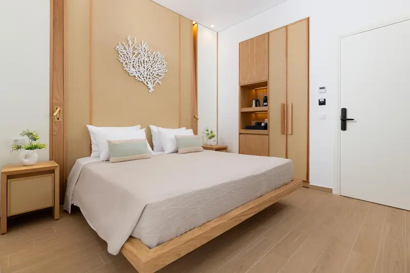 Une chambre lumineuse avec un grand lit et une décoration murale.