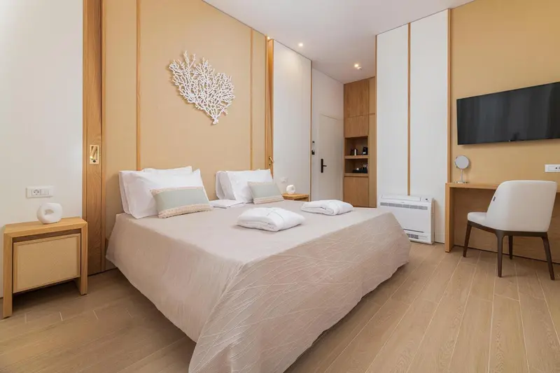 Une chambre lumineuse avec un grand lit et un bureau.