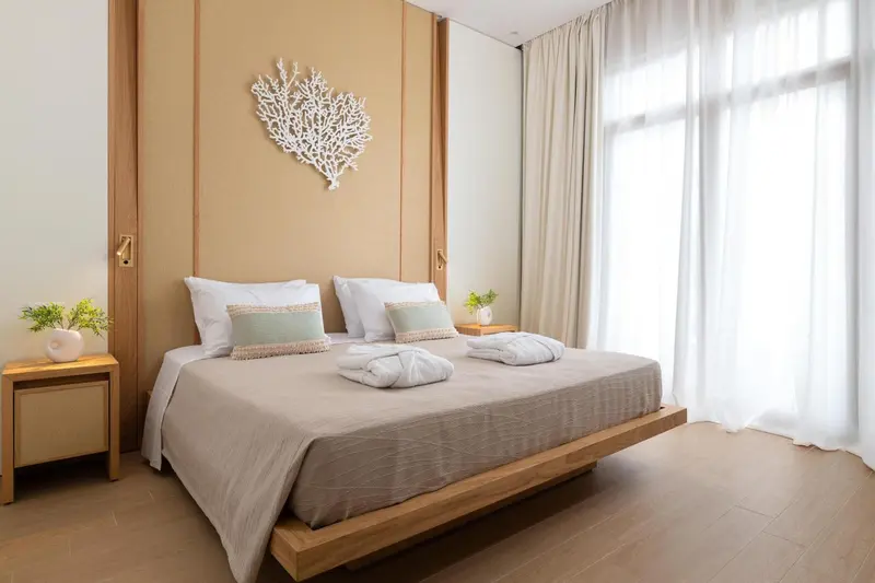 Lit double avec décoration murale en forme de corail dans une chambre lumineuse.