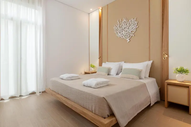 Une chambre lumineuse avec un grand lit et une décoration murale.
