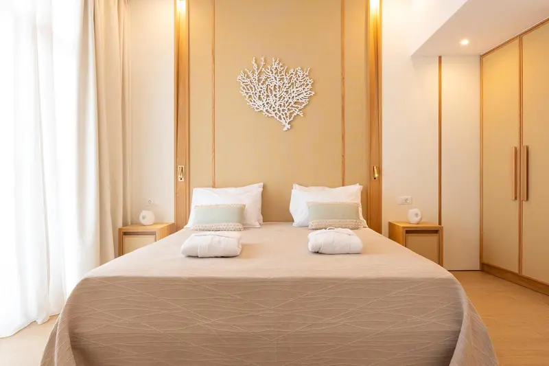 Une chambre lumineuse avec un grand lit et une décoration murale.