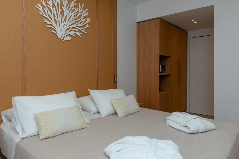 Lit préparé avec oreillers et décoration murale en forme de corail.