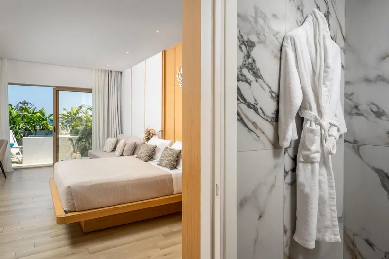 Une chambre lumineuse avec un grand lit et un accès à une terrasse.