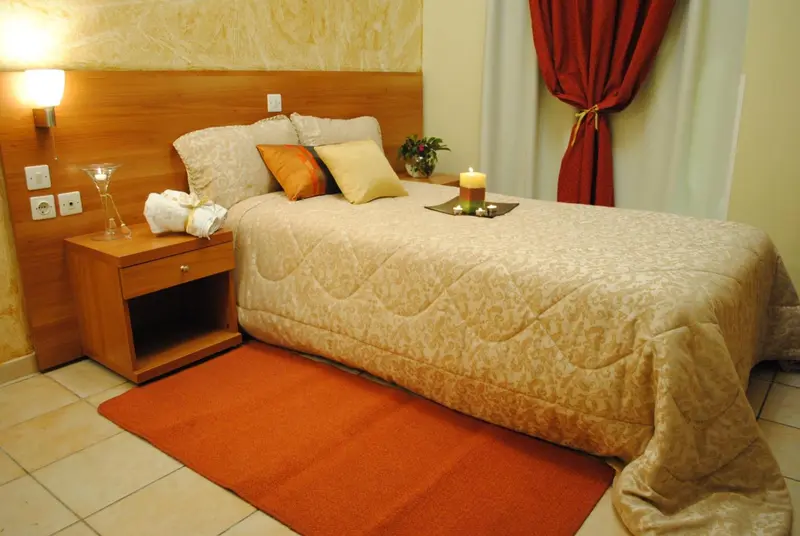Une chambre avec un lit recouvert d'une courtepointe et de coussins.