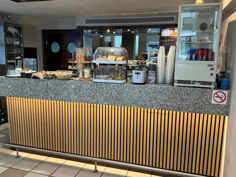 Un comptoir de buffet propose des viennoiseries et des boissons.