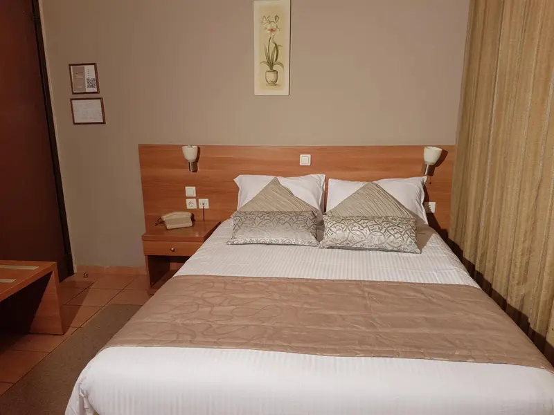 Une chambre avec un grand lit et une décoration sobre.