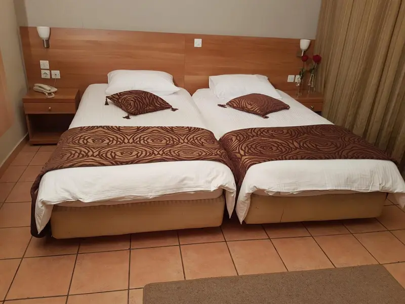 Deux lits simples avec une décoration florale dans une chambre.