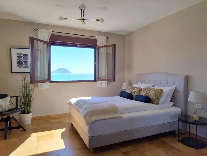 Une chambre lumineuse avec un grand lit et une vue sur la mer.