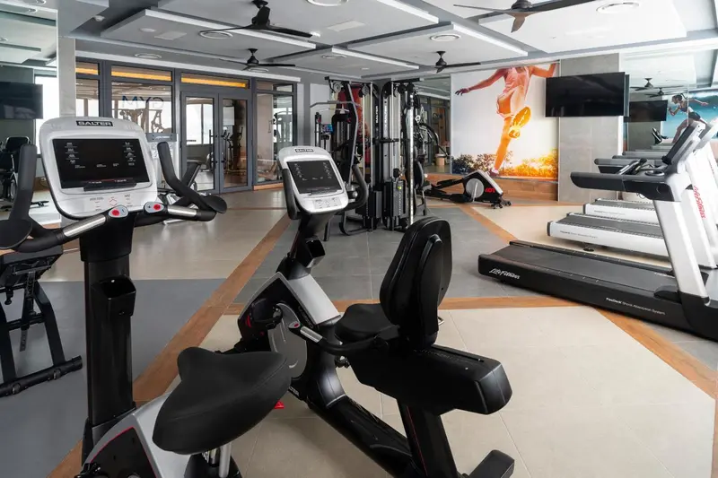 Une salle de sport lumineuse avec divers équipements de fitness.
