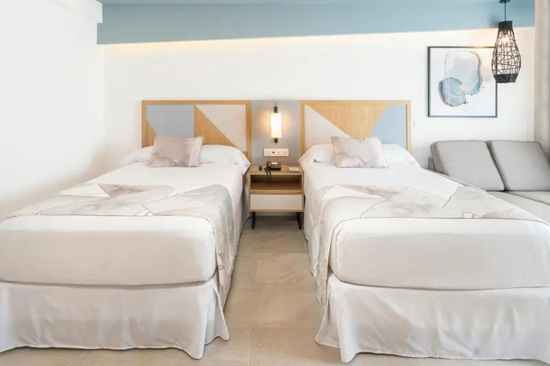 Deux lits simples dans une chambre lumineuse et moderne.