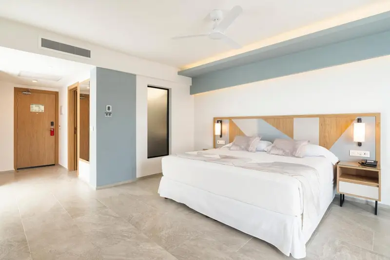 Une chambre lumineuse avec un grand lit et une décoration moderne.