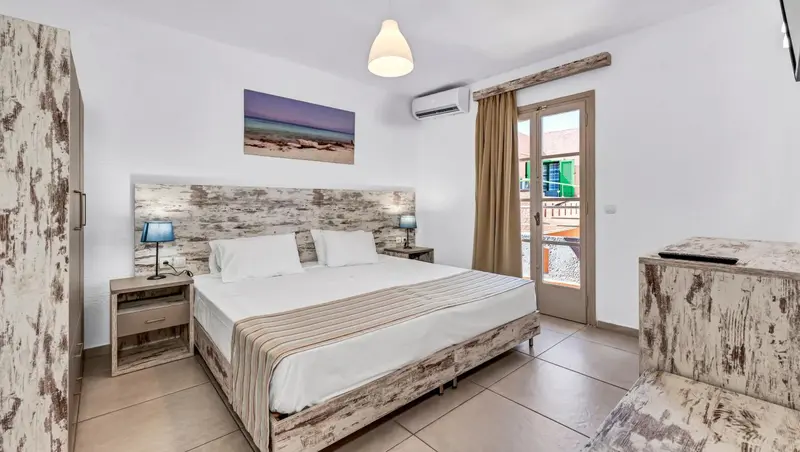 Une chambre lumineuse avec un grand lit et une décoration moderne.