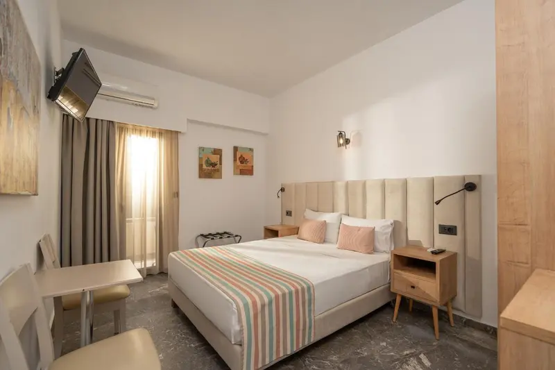 Une chambre lumineuse avec un grand lit et une table.