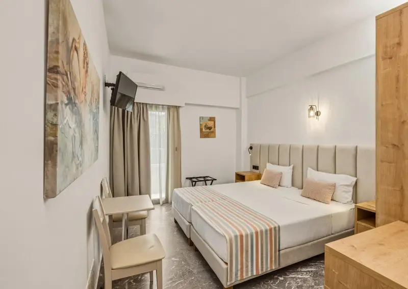 Une chambre lumineuse avec un grand lit et un coin salon.