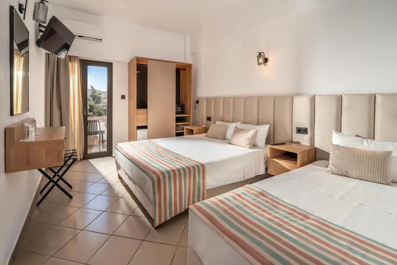 Une chambre lumineuse avec deux lits et une table de chevet.