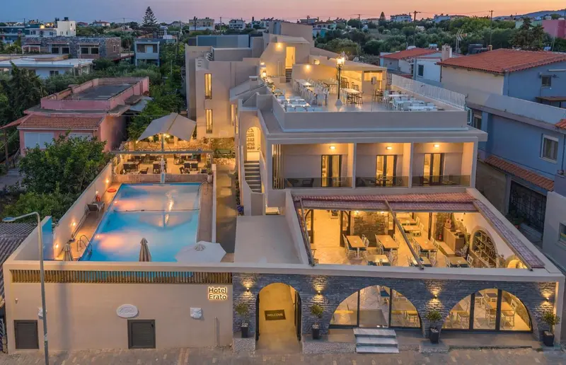 Vue aérienne d'un bâtiment blanc avec une piscine et des terrasses.