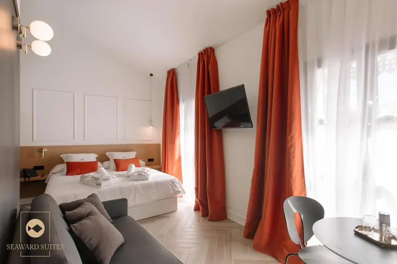 Chambre lumineuse avec un grand lit et un canapé.