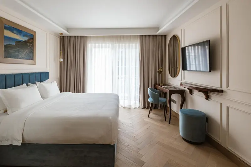 Une chambre lumineuse avec un grand lit et un coin bureau.