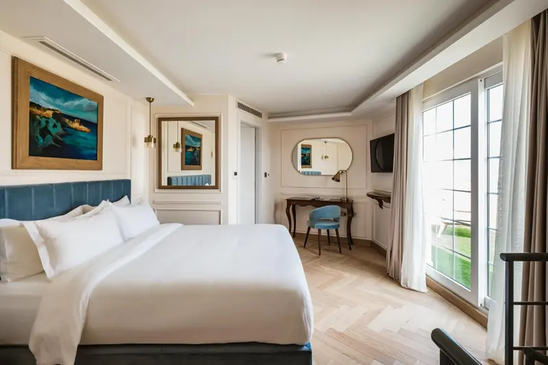 Une chambre lumineuse avec un grand lit et un bureau.