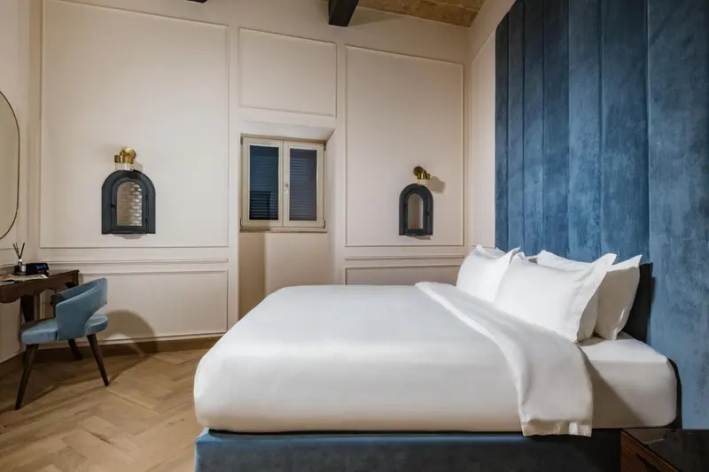 Une chambre lumineuse avec un grand lit et un bureau.