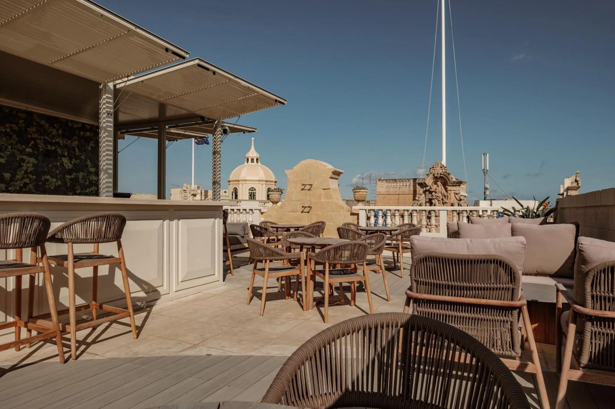 Terrasse aménagée avec mobilier de détente et vue sur un paysage urbain.
