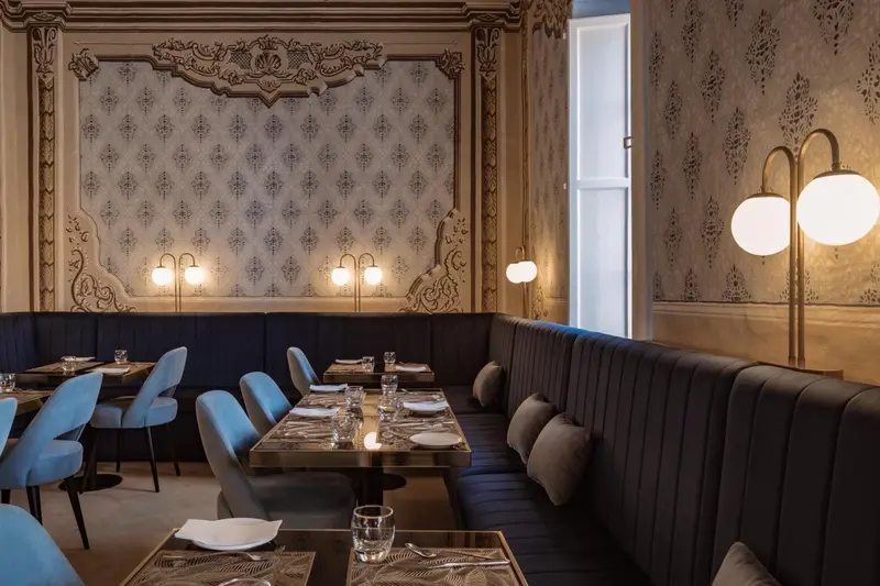 Une salle de restaurant élégante avec des tables dressées et des banquettes confortables.