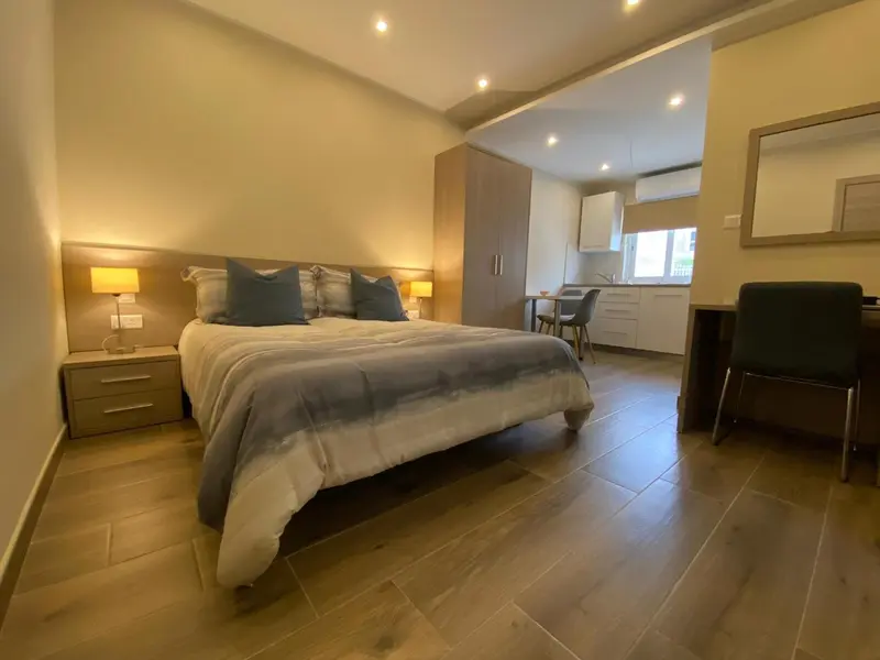 Une chambre lumineuse avec un lit double et un espace repas.