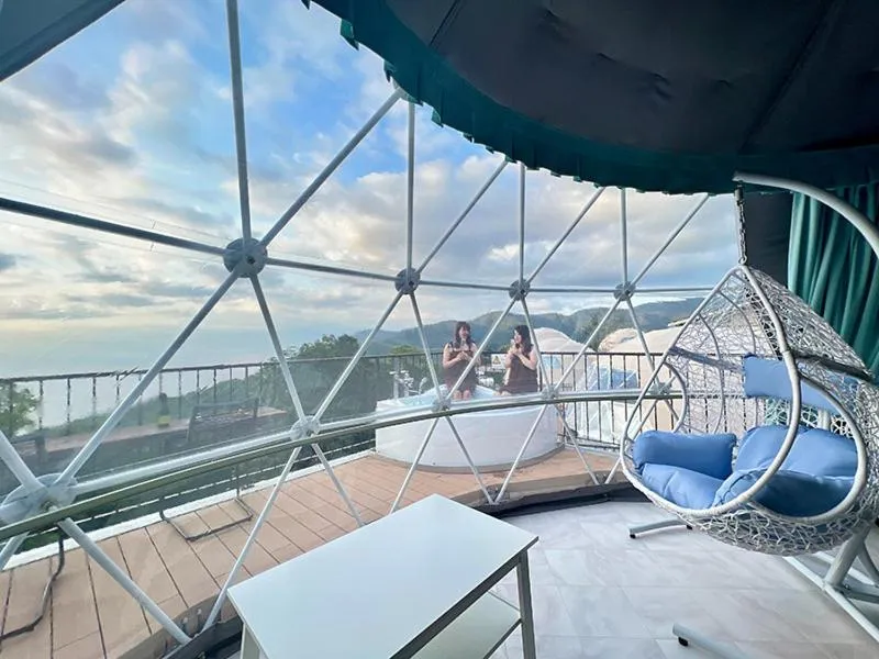 Deux femmes sont assises dans un jacuzzi sur une terrasse couverte avec vue sur la mer.