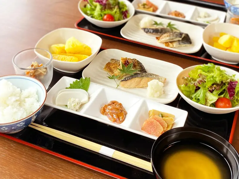 Assiette de plats japonais variés, riz, poisson et salade.