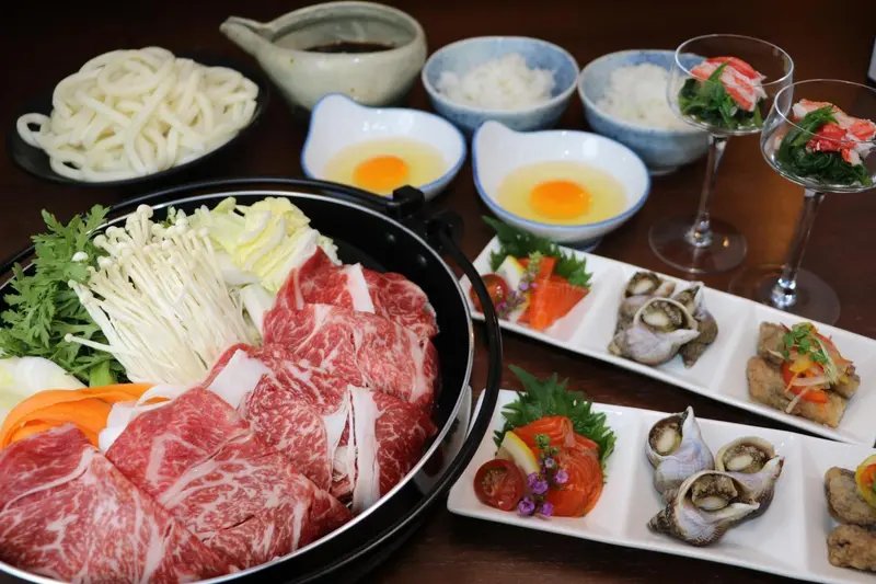 Assiette de nourriture japonaise avec viande, légumes et fruits de mer.