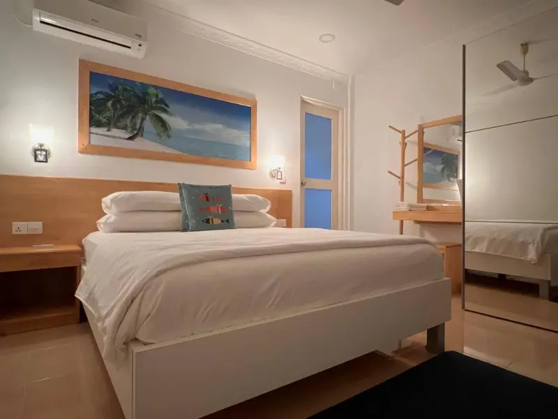 Une chambre lumineuse avec un grand lit et une décoration tropicale.