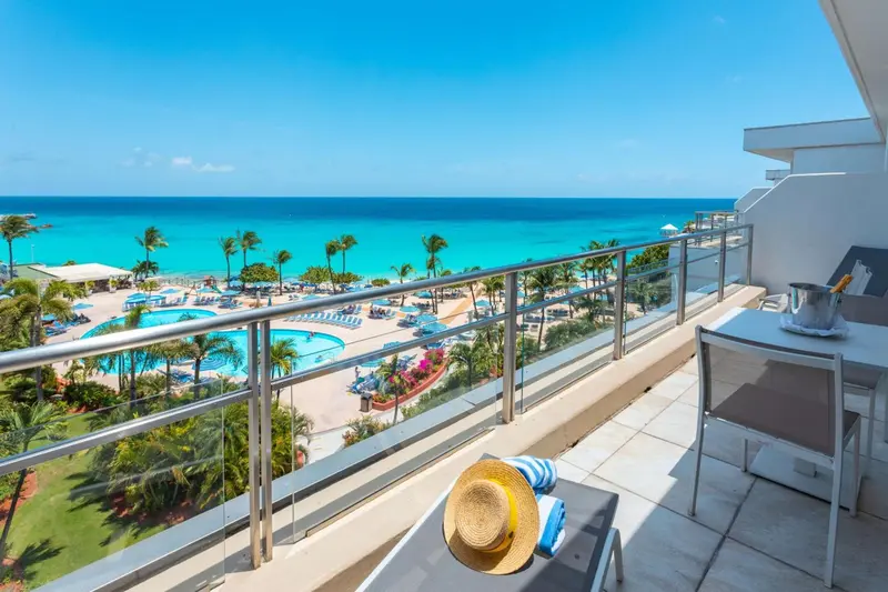 Vue d'un balcon avec une terrasse donnant sur une plage et la mer.