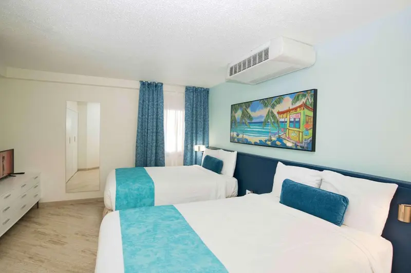 Une chambre lumineuse avec deux lits simples et une décoration tropicale.