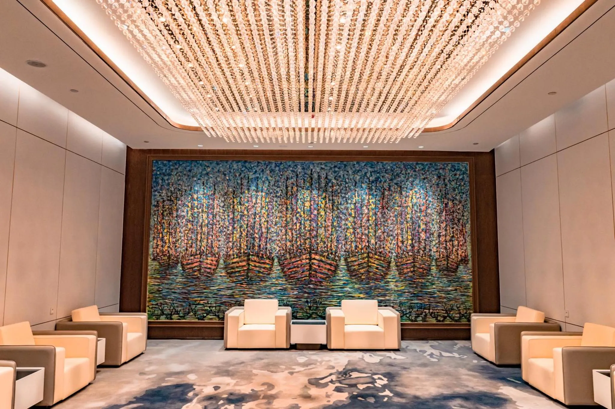 Un espace de détente avec des fauteuils et une œuvre d'art murale colorée.