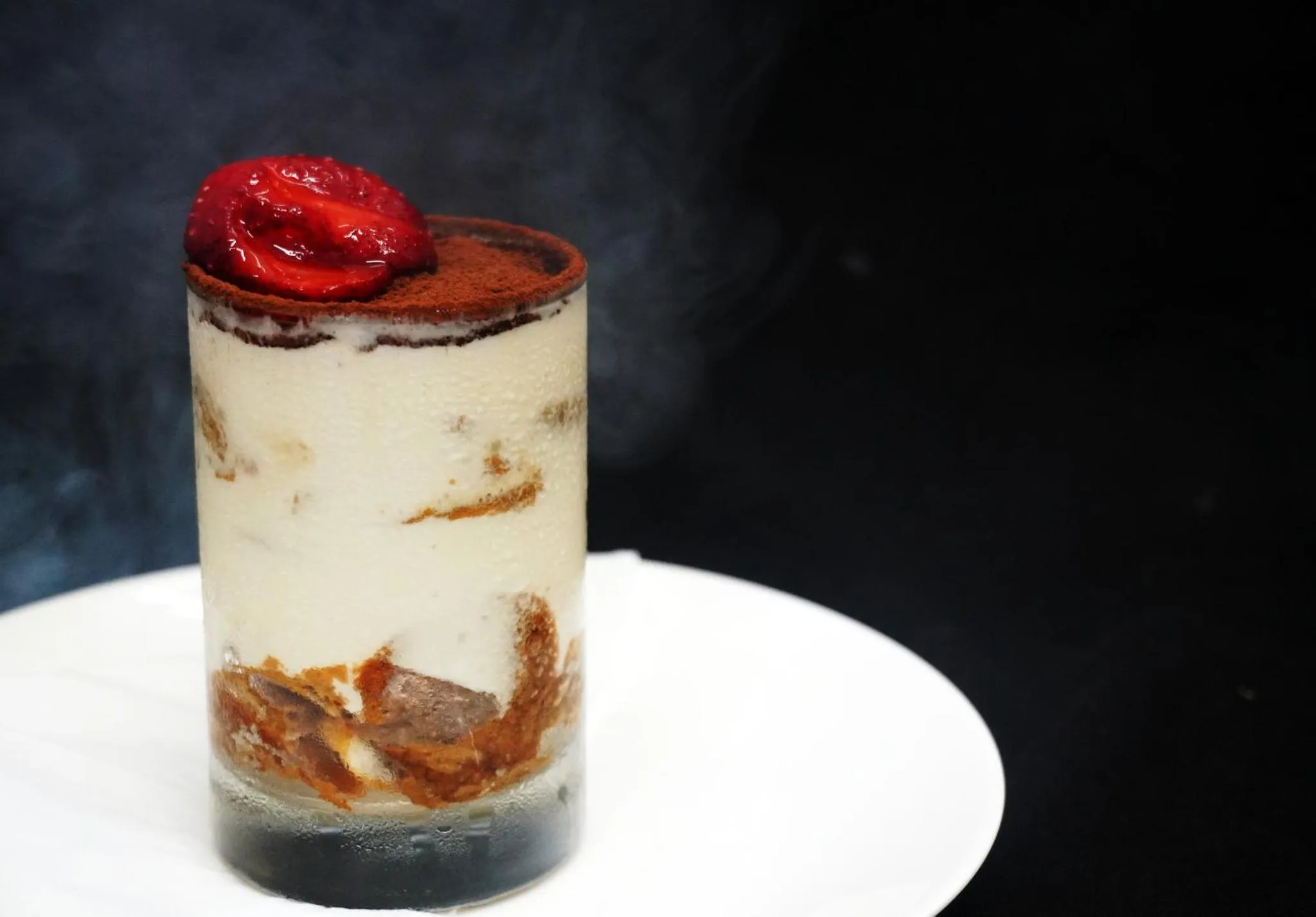 Un dessert crémeux au chocolat et aux biscuits est présenté dans un verre.