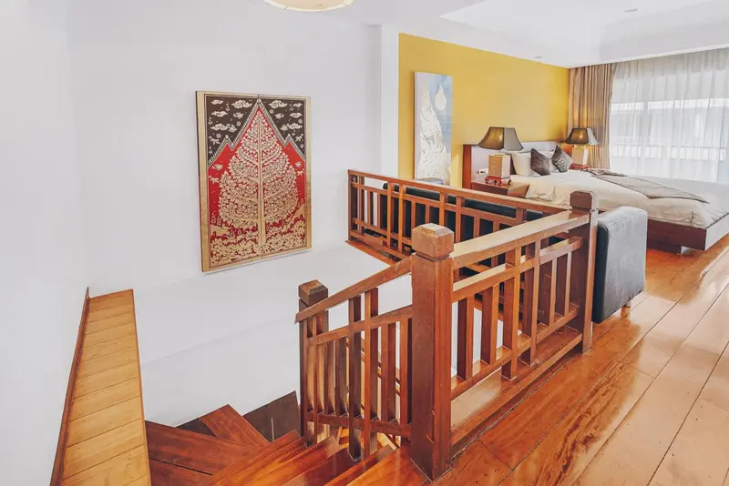Une chambre spacieuse avec un lit et un escalier en bois.