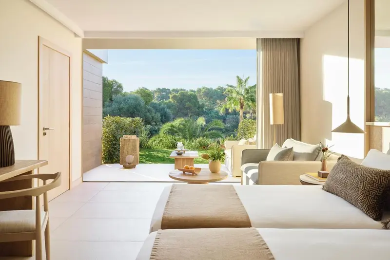 Une chambre lumineuse s'ouvre sur une vue verdoyante.