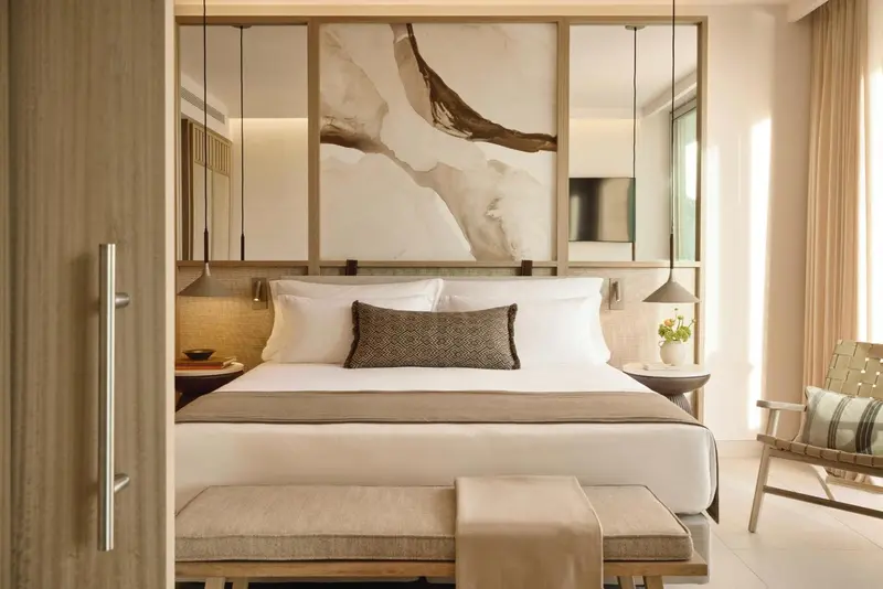 Une chambre lumineuse avec un grand lit et une décoration sobre.