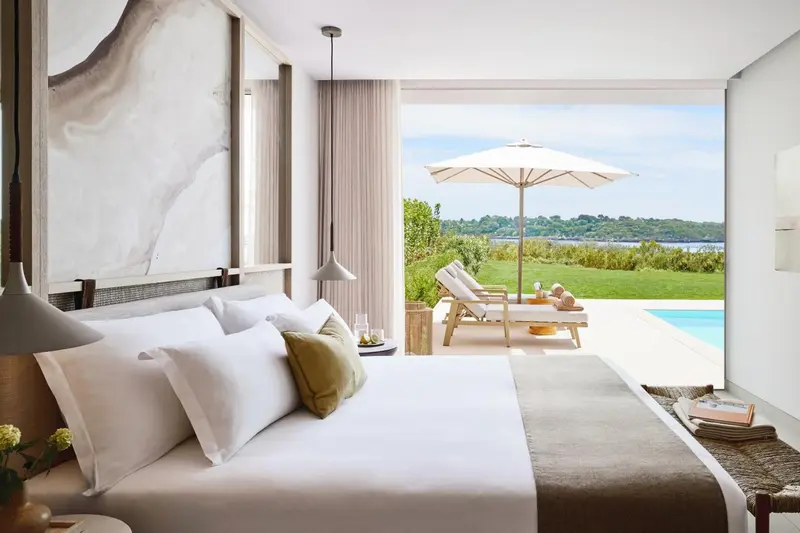 Une chambre lumineuse s'ouvre sur une terrasse avec vue sur la mer.