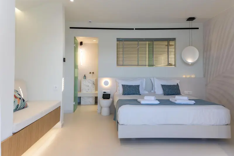 Une chambre lumineuse avec un grand lit et un espace détente.