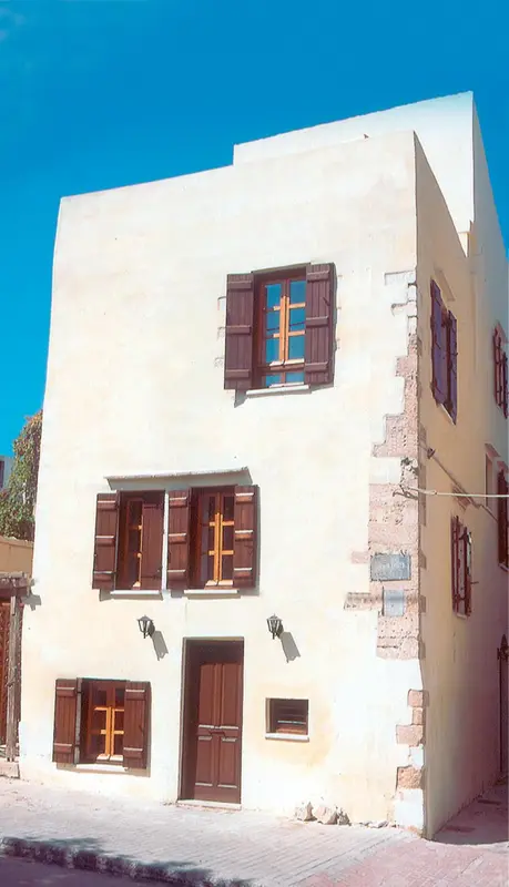Facade d'un bâtiment blanc à deux étages avec des volets marron.