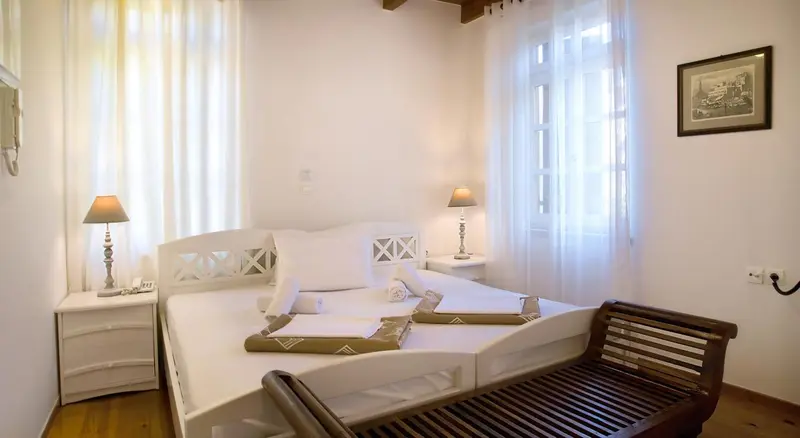 Une chambre lumineuse avec un grand lit et des tables de chevet.