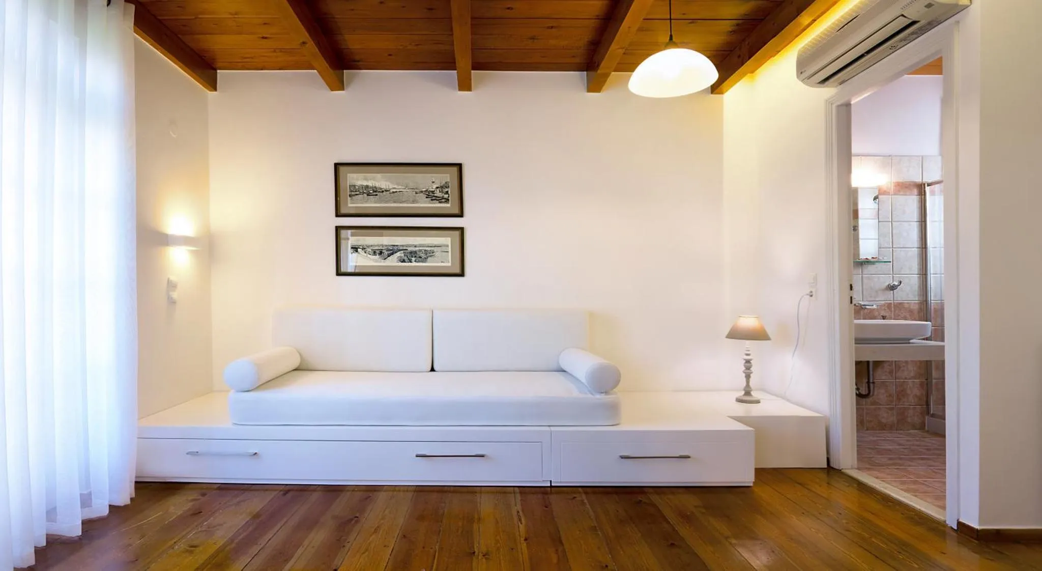 Espace de détente intérieur avec canapé blanc et décoration murale.