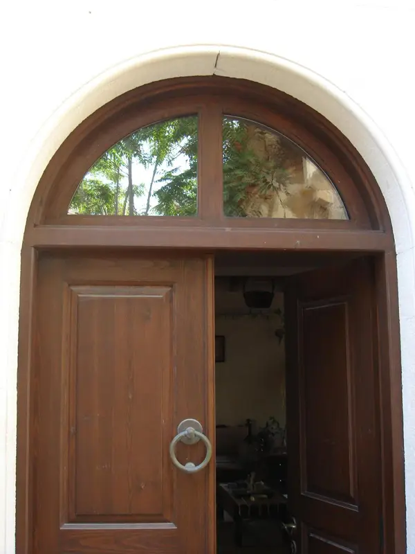 Une porte en bois brun orne une entrée arquée.