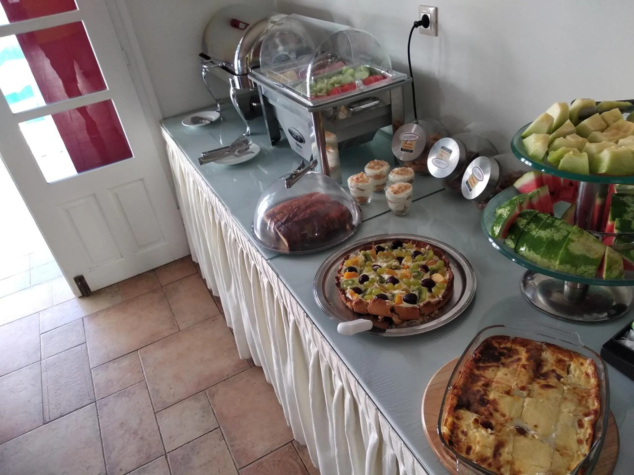 Un buffet propose des pâtisseries, des fruits et des plats préparés.
